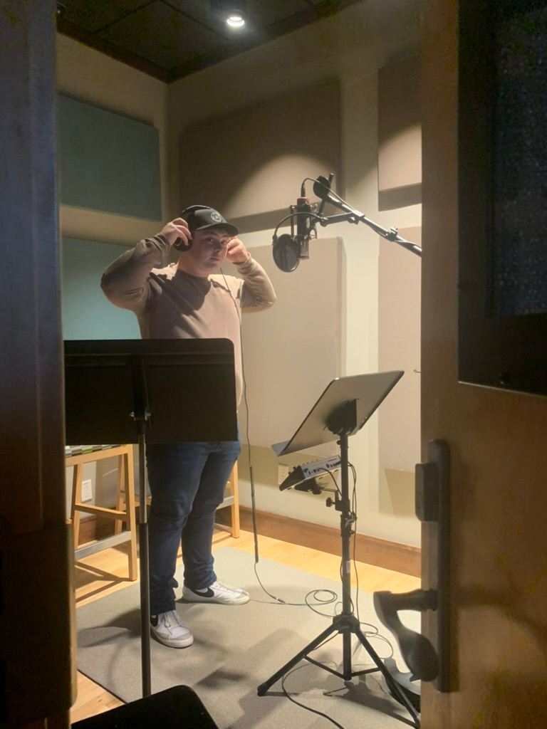Caleb preparing to record vocals in a studio booth